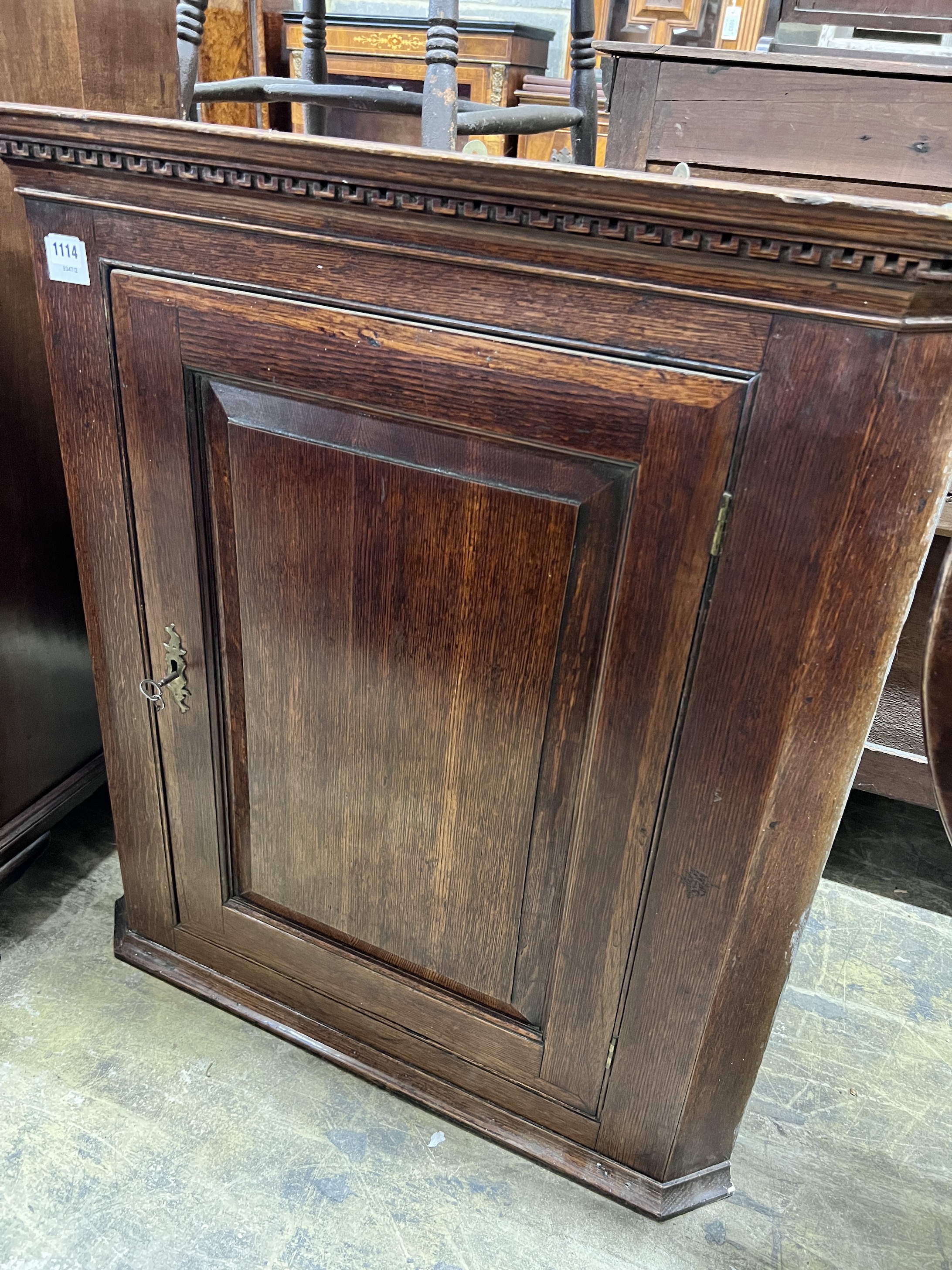 A George III oak hanging corner cabinet with serpentine shelves, width 84cm, height 91cm